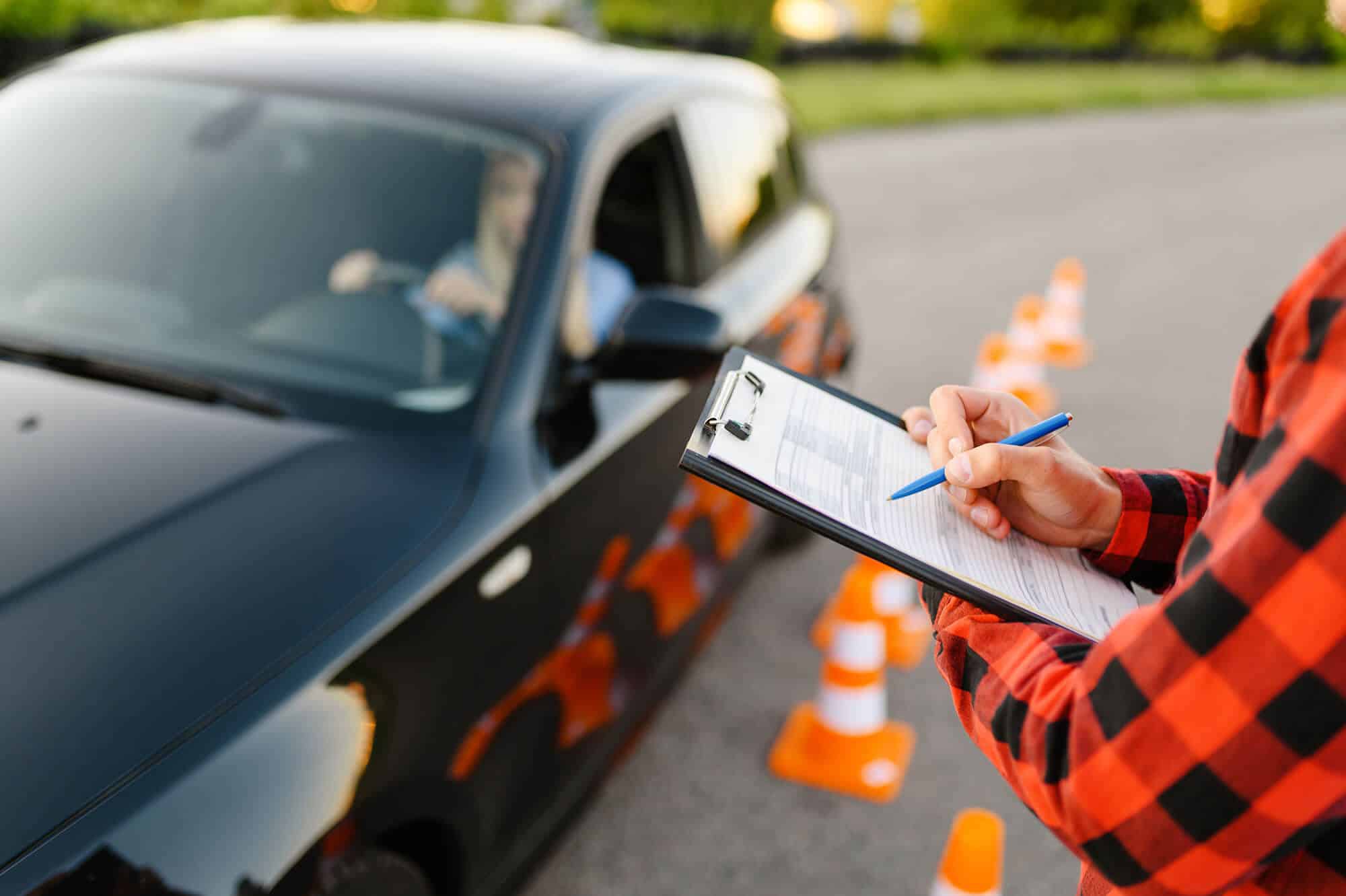 Instructor with checklist during driving exam